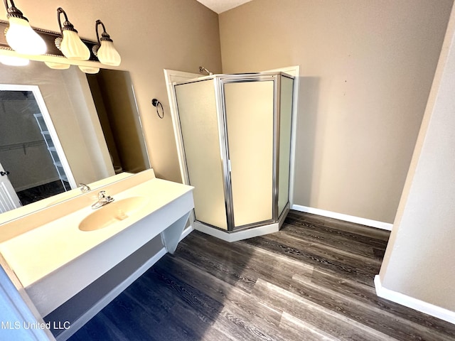 bathroom with hardwood / wood-style flooring, vanity, and walk in shower