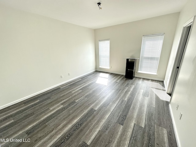 unfurnished living room with dark wood-type flooring