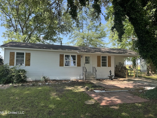 ranch-style home with entry steps, an attached carport, and a front yard