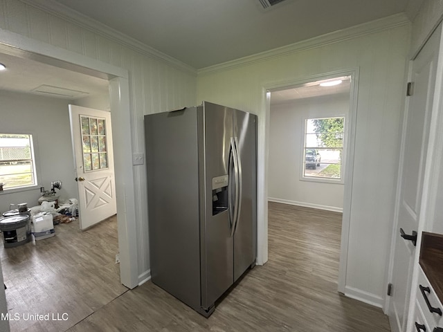 kitchen with stainless steel refrigerator with ice dispenser, dark wood-type flooring, baseboards, and crown molding