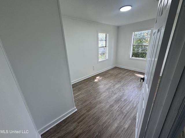 empty room with baseboards and dark wood finished floors