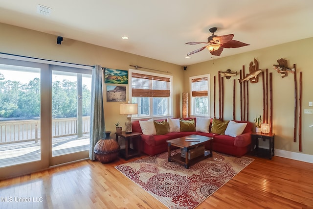 living room with light hardwood / wood-style floors, plenty of natural light, and ceiling fan