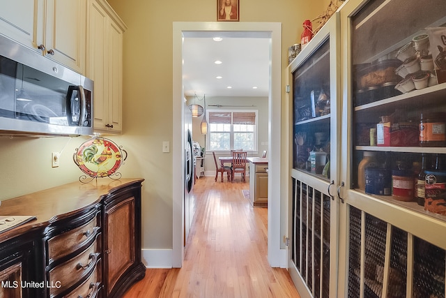 hallway with light hardwood / wood-style floors