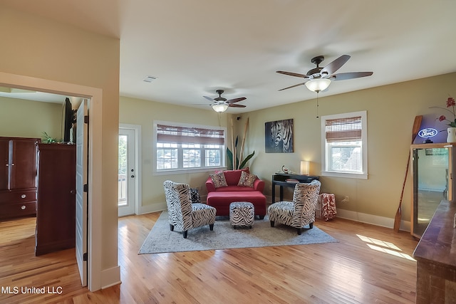 living area featuring a wealth of natural light, light hardwood / wood-style flooring, and ceiling fan