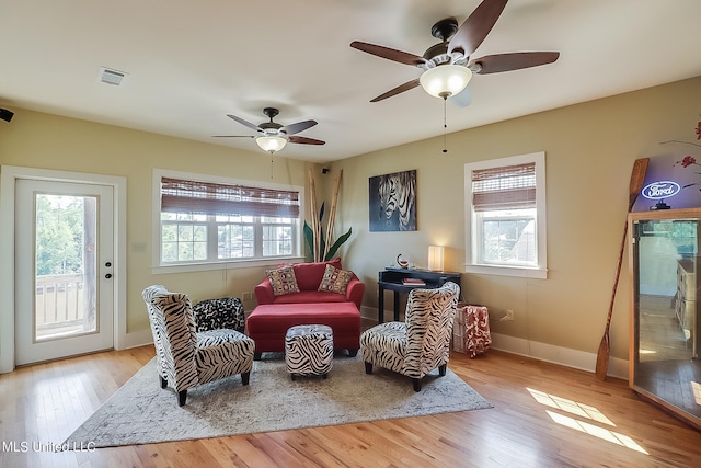 sitting room with light wood-type flooring and ceiling fan