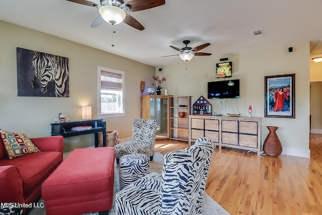 living room with light hardwood / wood-style floors and ceiling fan