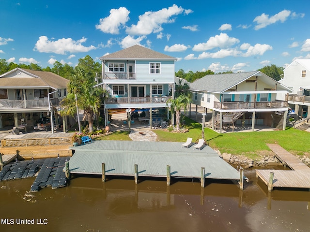 rear view of house featuring a patio area, a balcony, a water view, and a lawn