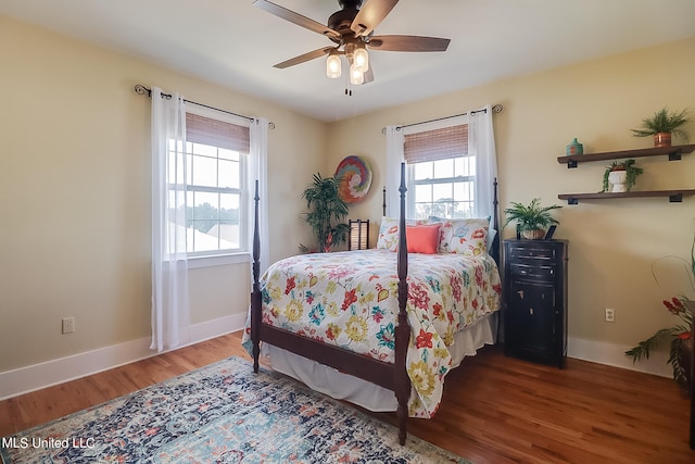 bedroom with hardwood / wood-style floors, multiple windows, and ceiling fan