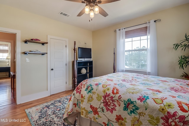 bedroom featuring multiple windows, wood-type flooring, and ceiling fan