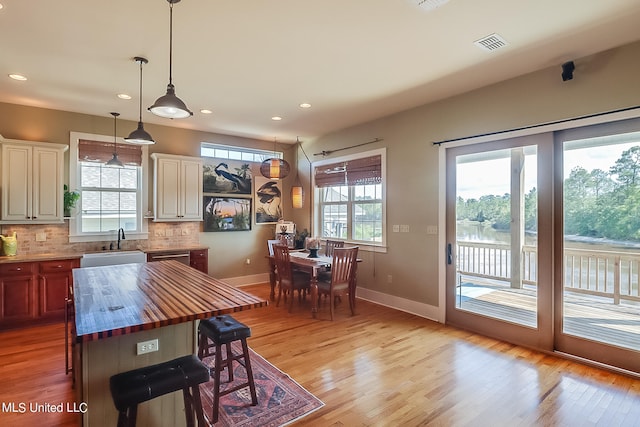 kitchen with light hardwood / wood-style flooring, wooden counters, and a healthy amount of sunlight