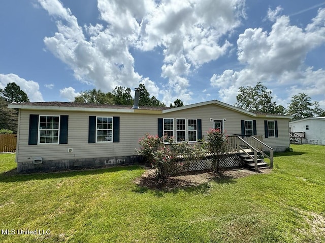 back of property featuring a wooden deck and a yard