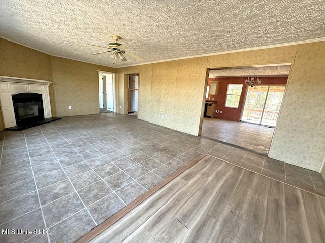 unfurnished living room with wood-type flooring, ceiling fan with notable chandelier, and ornamental molding