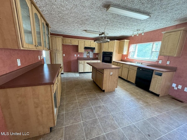 kitchen with sink, light tile patterned floors, a center island, and black appliances