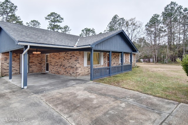 view of side of home featuring concrete driveway, a carport, brick siding, and a lawn