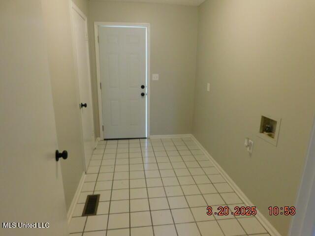 165 Christian College Rd, Senatobia, MS 38668 - laundry room featuring hookup for a washing machine, light tile patterned floors, and baseboards