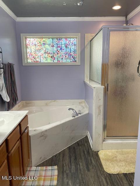 bathroom featuring vanity, crown molding, wood-type flooring, and shower with separate bathtub