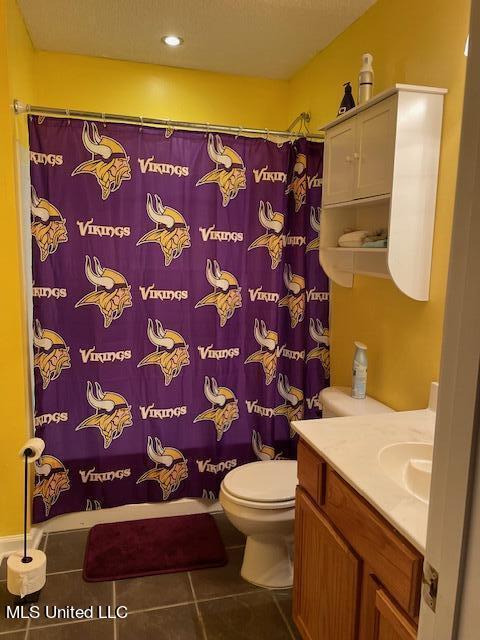 bathroom featuring vanity, tile patterned floors, and toilet