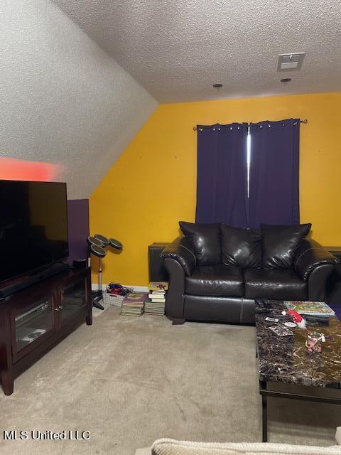 carpeted living room featuring vaulted ceiling and a textured ceiling