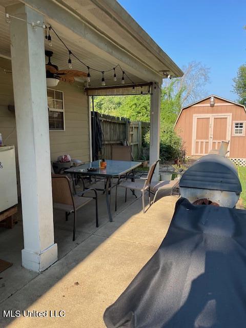 view of patio / terrace with ceiling fan and a storage unit