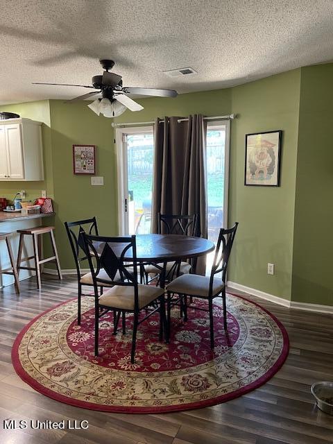 dining room with hardwood / wood-style floors, a textured ceiling, and ceiling fan