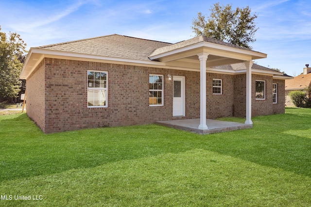 back of property with a lawn and a patio