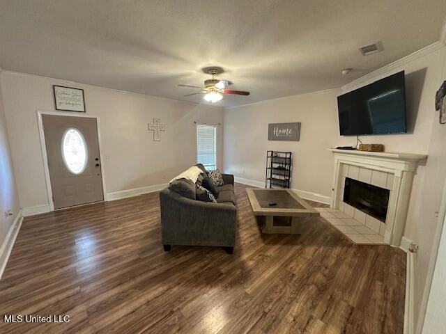 living room featuring ceiling fan, a fireplace, ornamental molding, and hardwood / wood-style flooring