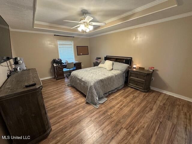 bedroom featuring a raised ceiling, ceiling fan, hardwood / wood-style floors, and crown molding