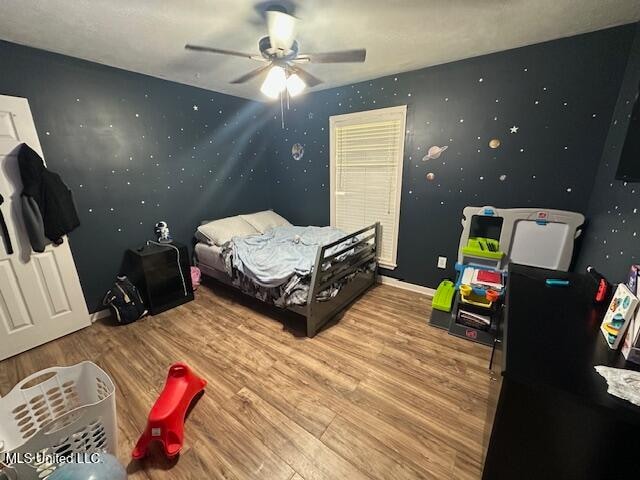 bedroom with ceiling fan and hardwood / wood-style flooring