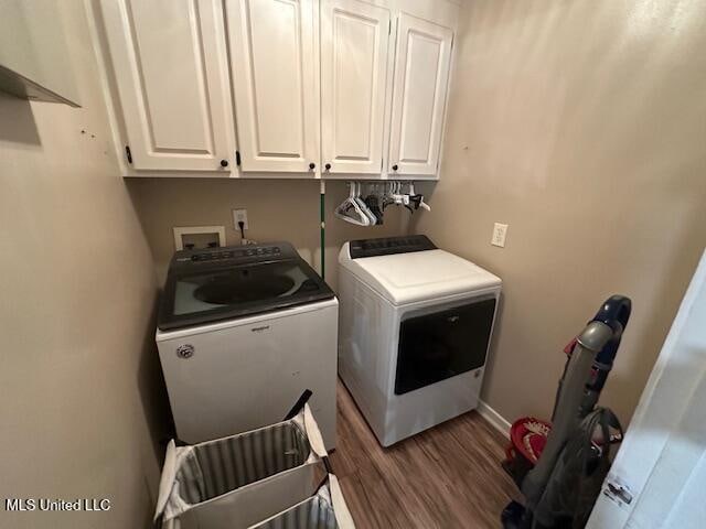 laundry area featuring independent washer and dryer, cabinets, and hardwood / wood-style flooring