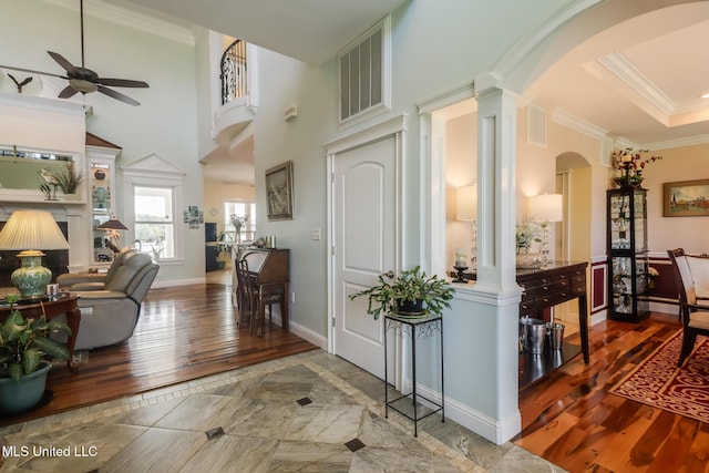 13129 Jordan Bluff Rd, Kiln, MS 39556 - entrance foyer with arched walkways, hardwood / wood-style floors, ceiling fan, decorative columns, and ornamental molding