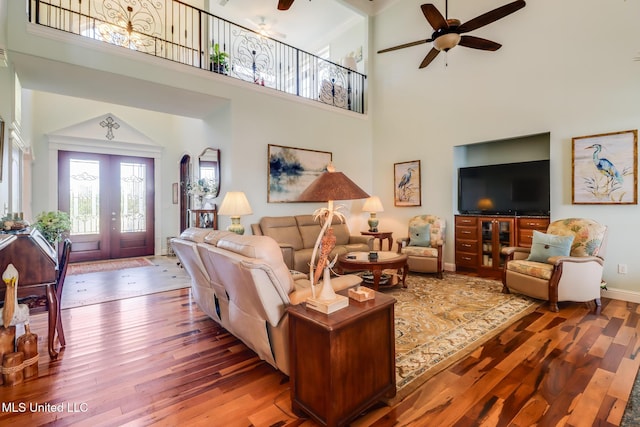 13129 Jordan Bluff Rd, Kiln, MS 39556 - living area with ceiling fan, wood-type flooring, a high ceiling, and baseboards