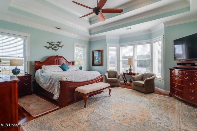 13129 Jordan Bluff Rd, Kiln, MS 39556 - bedroom featuring a tray ceiling, wood finished floors, crown molding, a ceiling fan, and baseboards
