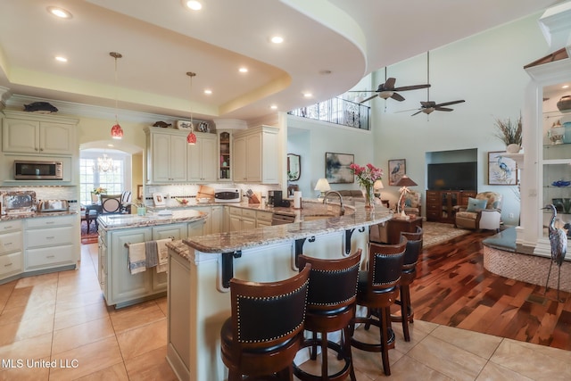 13129 Jordan Bluff Rd, Kiln, MS 39556 - kitchen featuring stainless steel microwave, a sink, light tile patterned floors, a ceiling fan, and tasteful backsplash