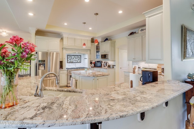 13129 Jordan Bluff Rd, Kiln, MS 39556 - kitchen with appliances with stainless steel finishes, a sink, decorative backsplash, light stone counters, and a peninsula