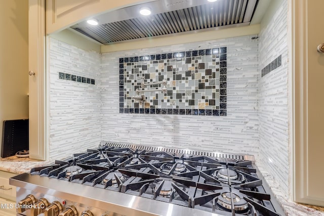 13129 Jordan Bluff Rd, Kiln, MS 39556 - kitchen view of stovetop, custom range hood, decorative backsplash, and arched walkways