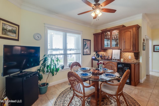 13129 Jordan Bluff Rd, Kiln, MS 39556 - dining area with wine cooler, a bar, light tile patterned floors, a ceiling fan, and crown molding