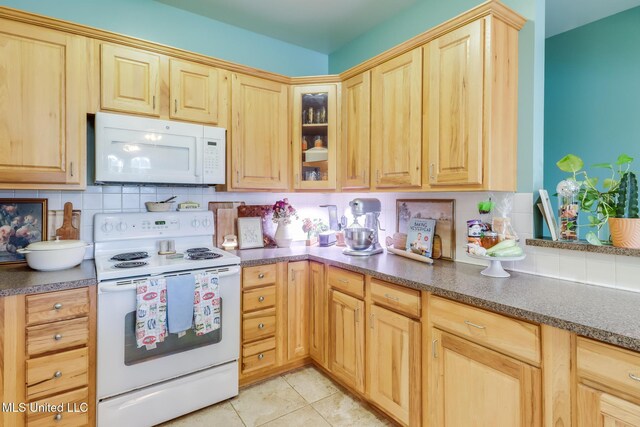 13129 Jordan Bluff Rd, Kiln, MS 39556 - kitchen with white appliances, light brown cabinets, tasteful backsplash, and dark countertops