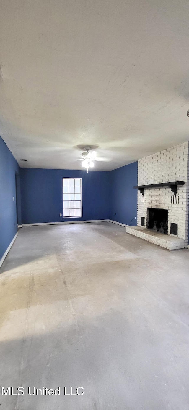 unfurnished living room with concrete floors and a brick fireplace