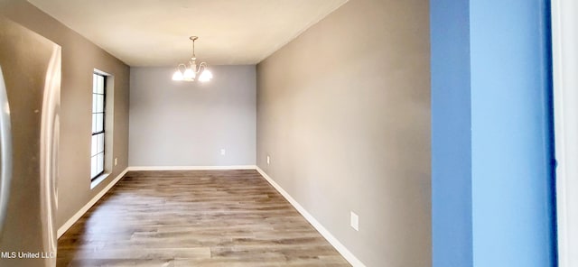 unfurnished dining area with hardwood / wood-style flooring and an inviting chandelier