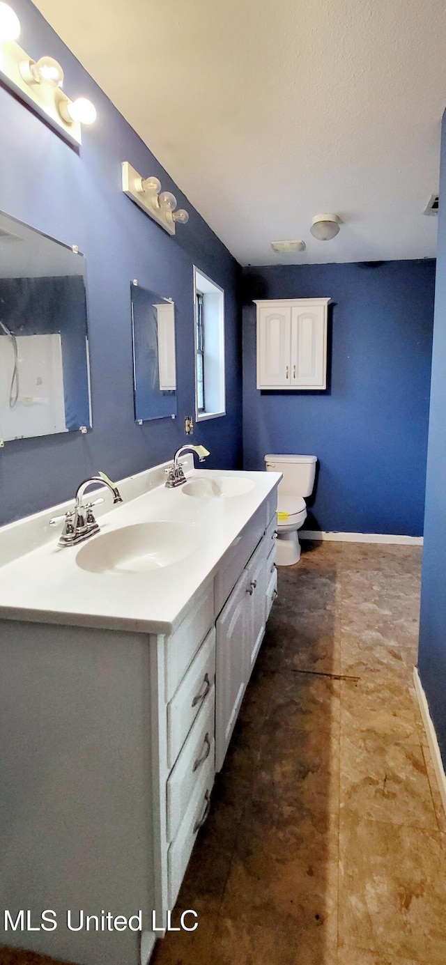 bathroom with vanity, a textured ceiling, and toilet