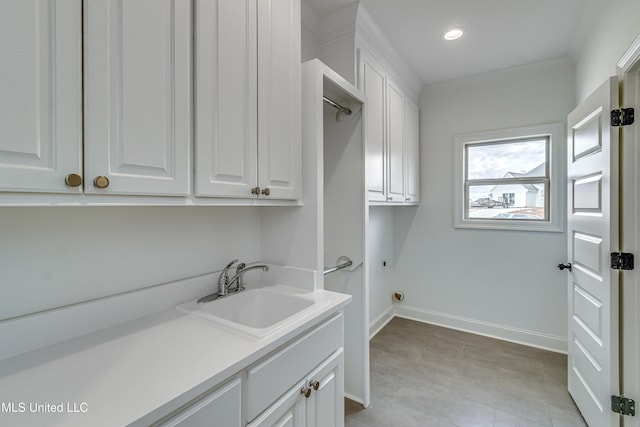 laundry area with cabinets and sink