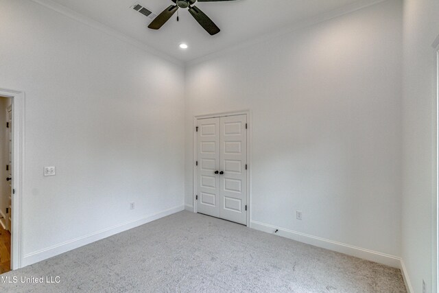 carpeted spare room featuring ceiling fan and ornamental molding