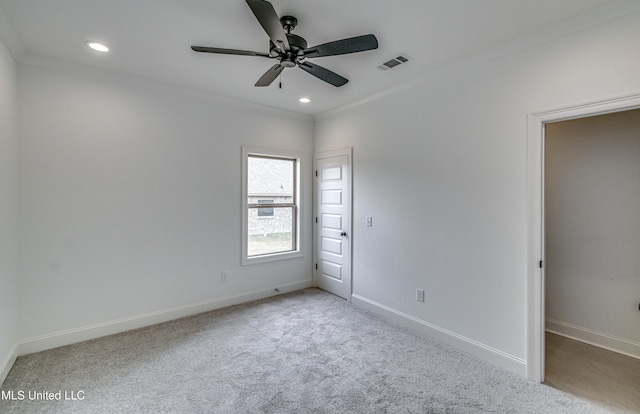 spare room with light colored carpet, ceiling fan, and ornamental molding