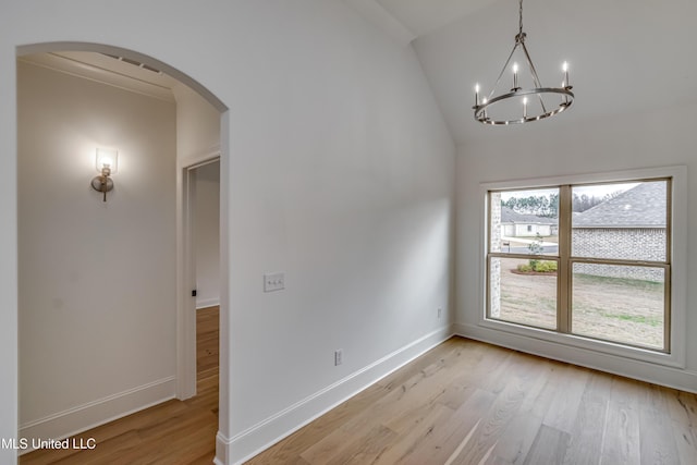 interior space featuring an inviting chandelier, vaulted ceiling, and light wood-type flooring