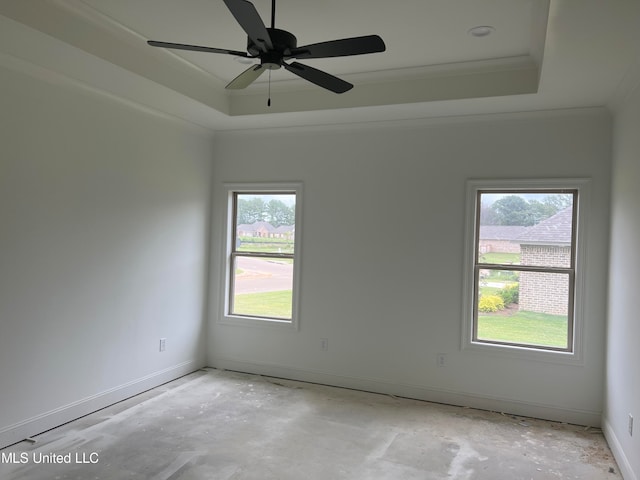 spare room with a tray ceiling, ceiling fan, crown molding, and a healthy amount of sunlight