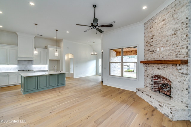 kitchen featuring a center island with sink, sink, light hardwood / wood-style flooring, ceiling fan, and white cabinetry