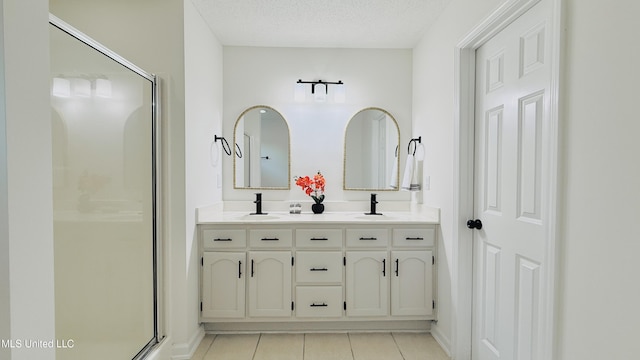 2595 Hunters Pointe Dr, Southaven, MS 38672 - full bathroom featuring tile patterned flooring, a shower stall, double vanity, and a textured ceiling