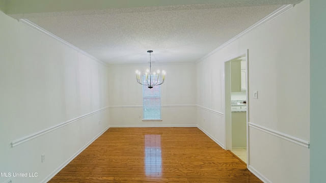 2595 Hunters Pointe Dr, Southaven, MS 38672 - empty room featuring ornamental molding, a chandelier, wood finished floors, and a textured ceiling