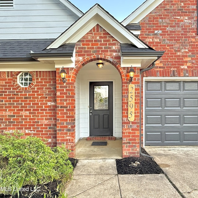 2595 Hunters Pointe Dr, Southaven, MS 38672 - view of exterior entry with brick siding, concrete driveway, and a shingled roof