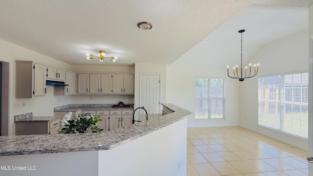 2595 Hunters Pointe Dr, Southaven, MS 38672 - kitchen featuring a chandelier, under cabinet range hood, light tile patterned flooring, hanging light fixtures, and light stone countertops